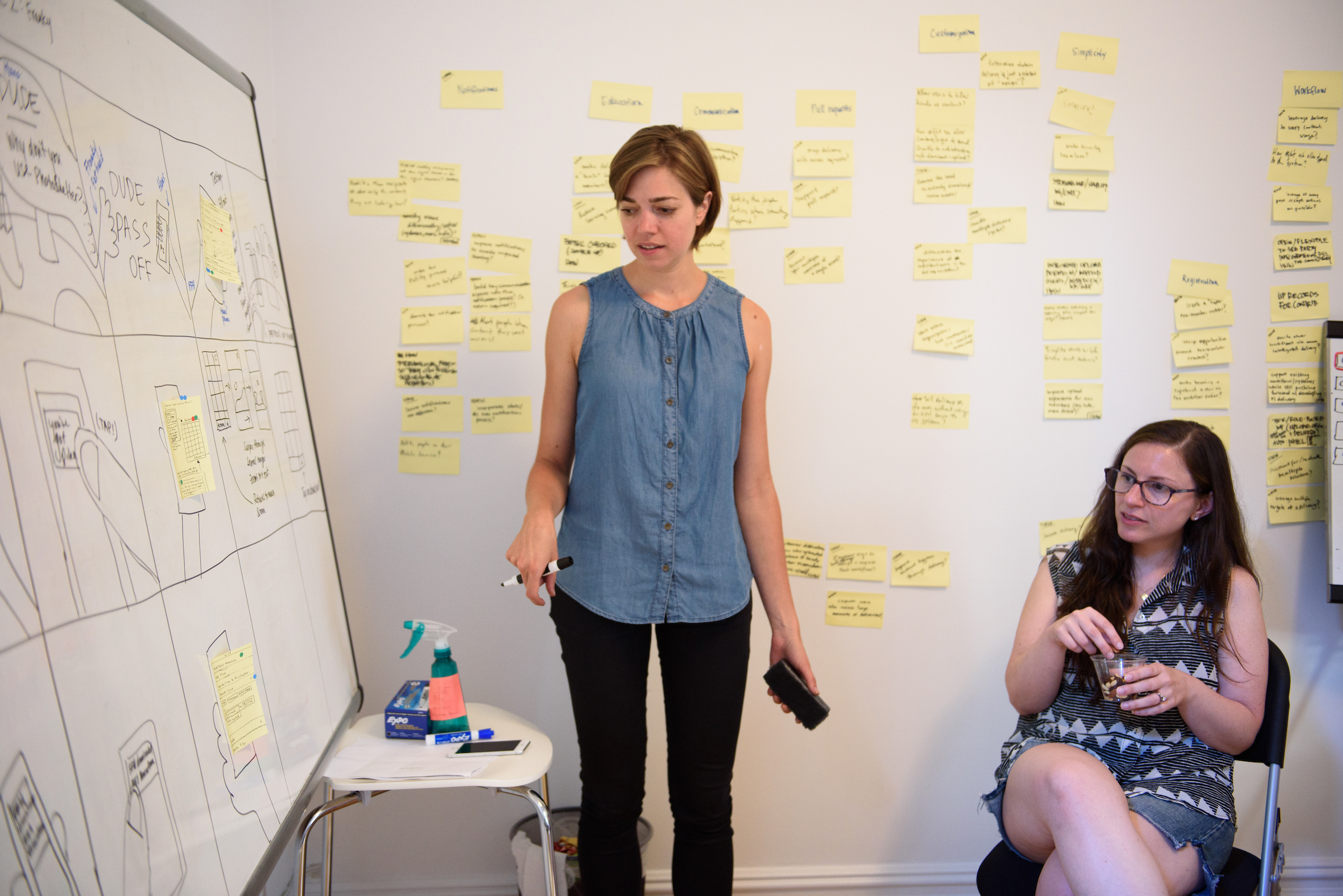 Kim Burgas and another GV sprint participant look at the whiteboard with the drawn storyboard.